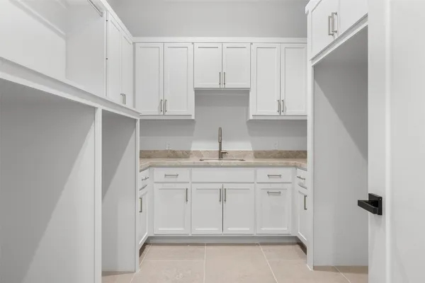 a kitchen with granite countertop white cabinets and a sink