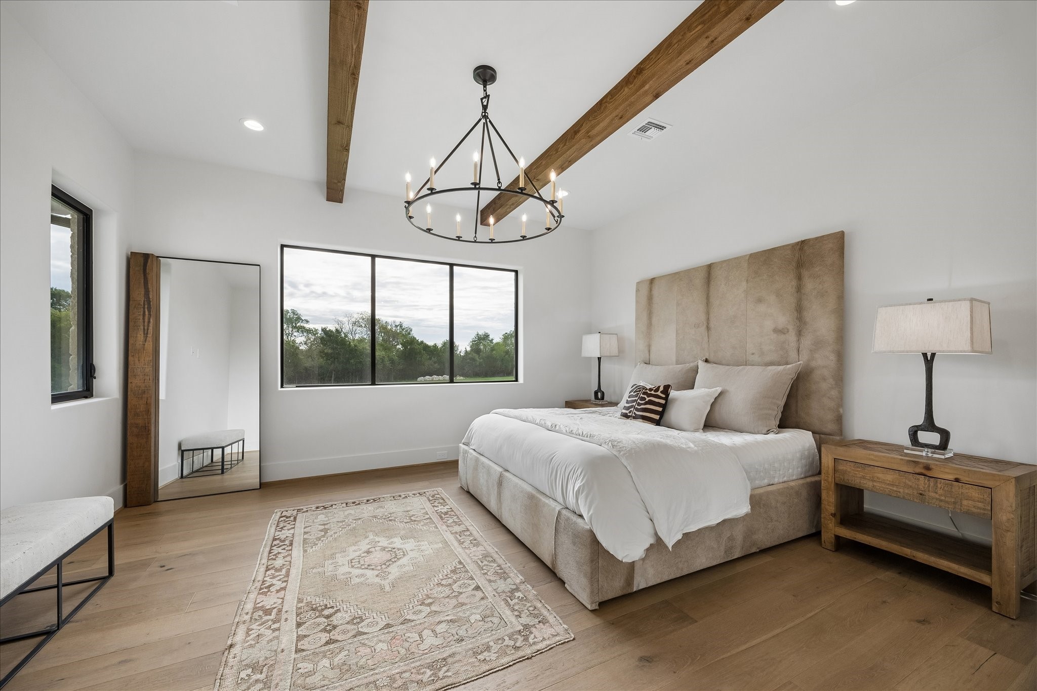 4961 Hartfield Road Round Top, TX 78954 - Photo 15 of 33 a bedroom with a large bed and a chandelier