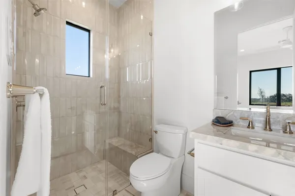 a bathroom with a granite countertop toilet a sink and a mirror