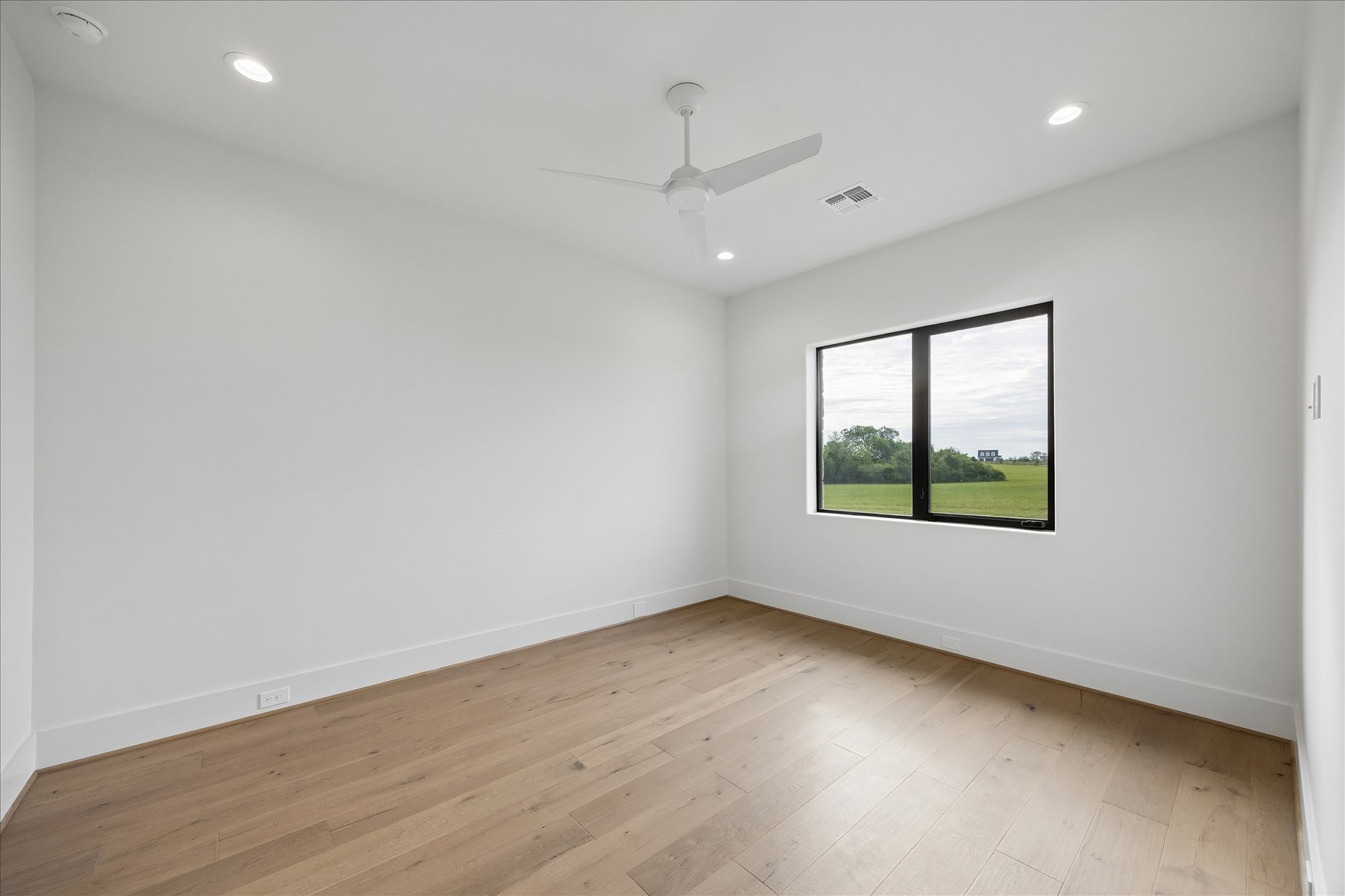 4961 Hartfield Road Round Top, TX 78954 - Photo 21 of 33 an empty room with wooden floor and windows