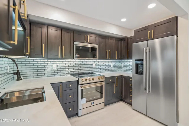 a view of a yard with plants and large trees