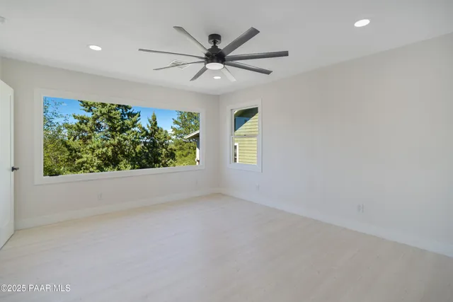 a view of wooden floor and a chandelier fan in a room