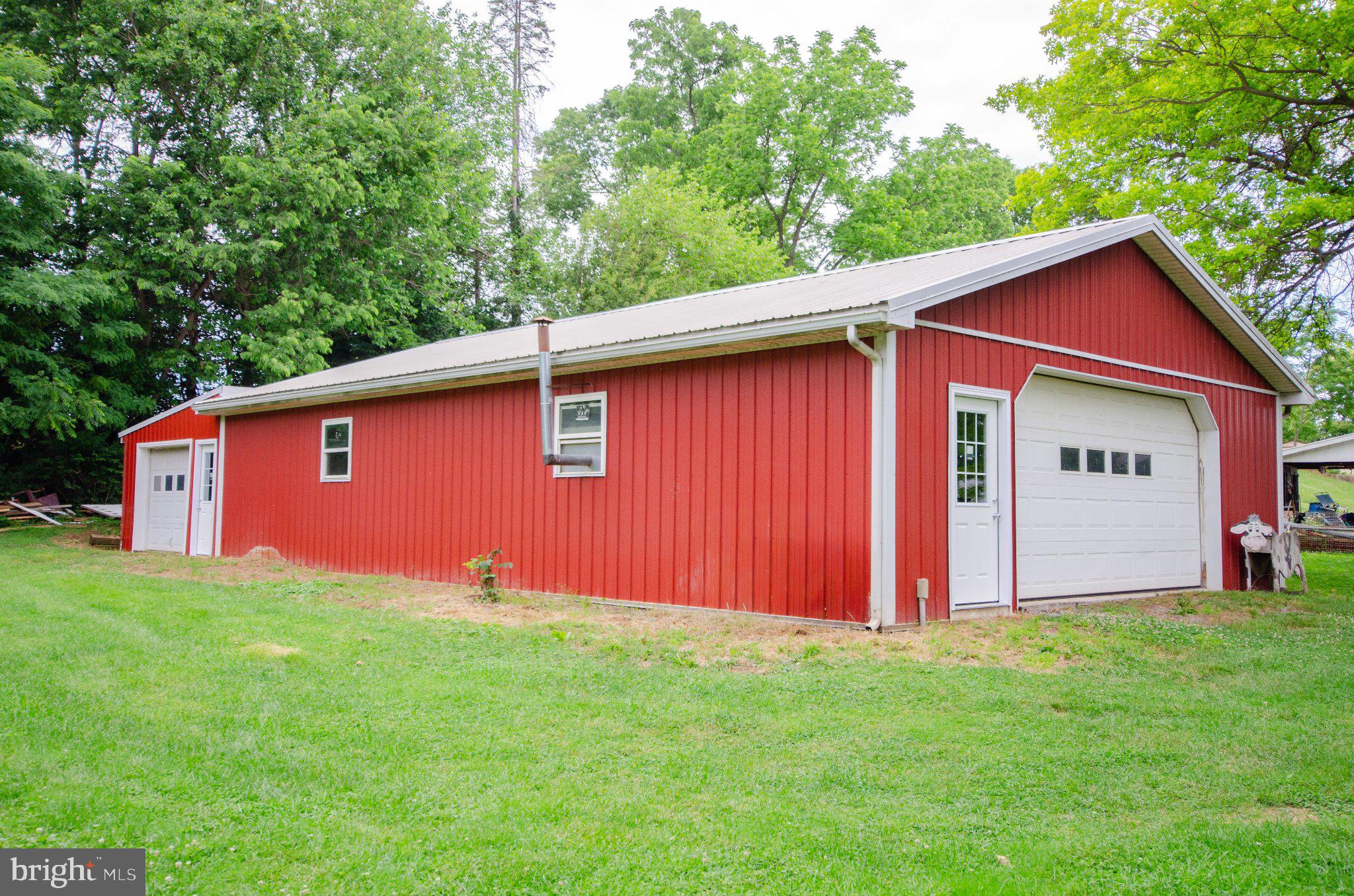 2615 Walnut Bottom Road Carlisle, PA 17015 - Photo 37 of 38 Charming red barn amidst lush greenery.