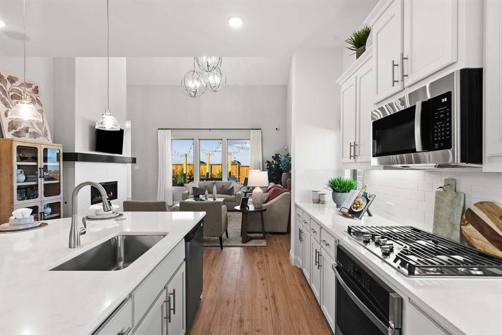 1439 Canadian Lane Van Alstyne, TX 75495 - Photo 7 of 21 a kitchen with a stove a sink and a flat screen tv