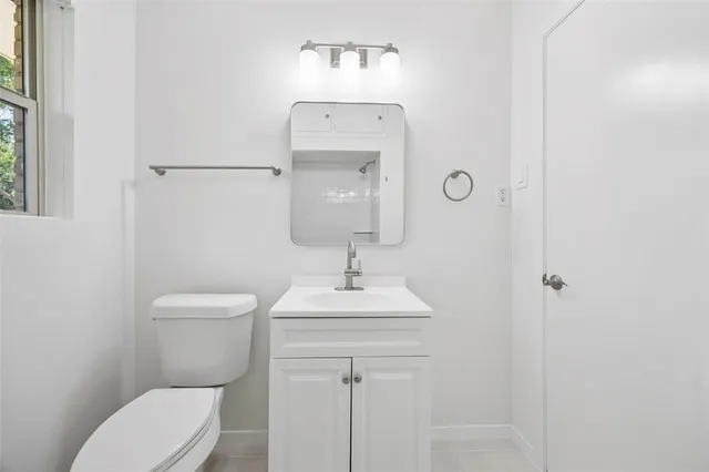 a bathroom with a toilet a sink and mirror