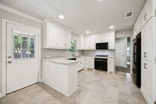a kitchen with a sink a counter top space stainless steel appliances and cabinets