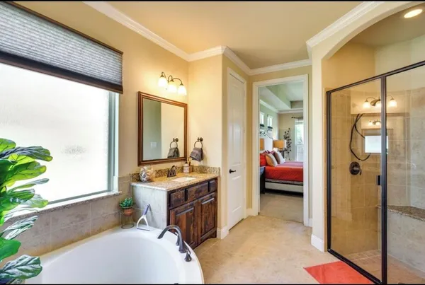 a en suite bathroom with a granite countertop tub and a large window