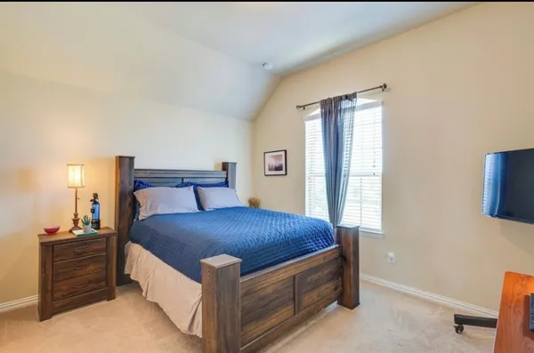 a bed sitting in a bedroom next to a window