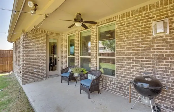 a view of a patio with a table and chairs and potted plants