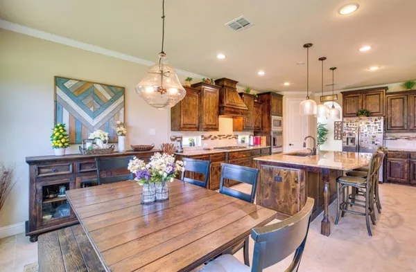 a dining room filled chandelier and wooden furniture