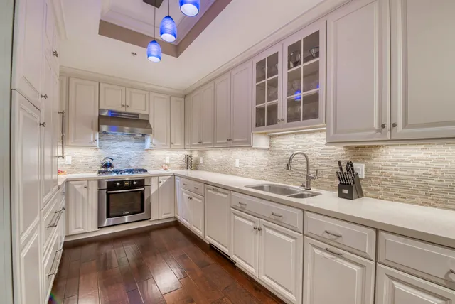 a kitchen with stainless steel appliances granite countertop white cabinets a sink and dishwasher