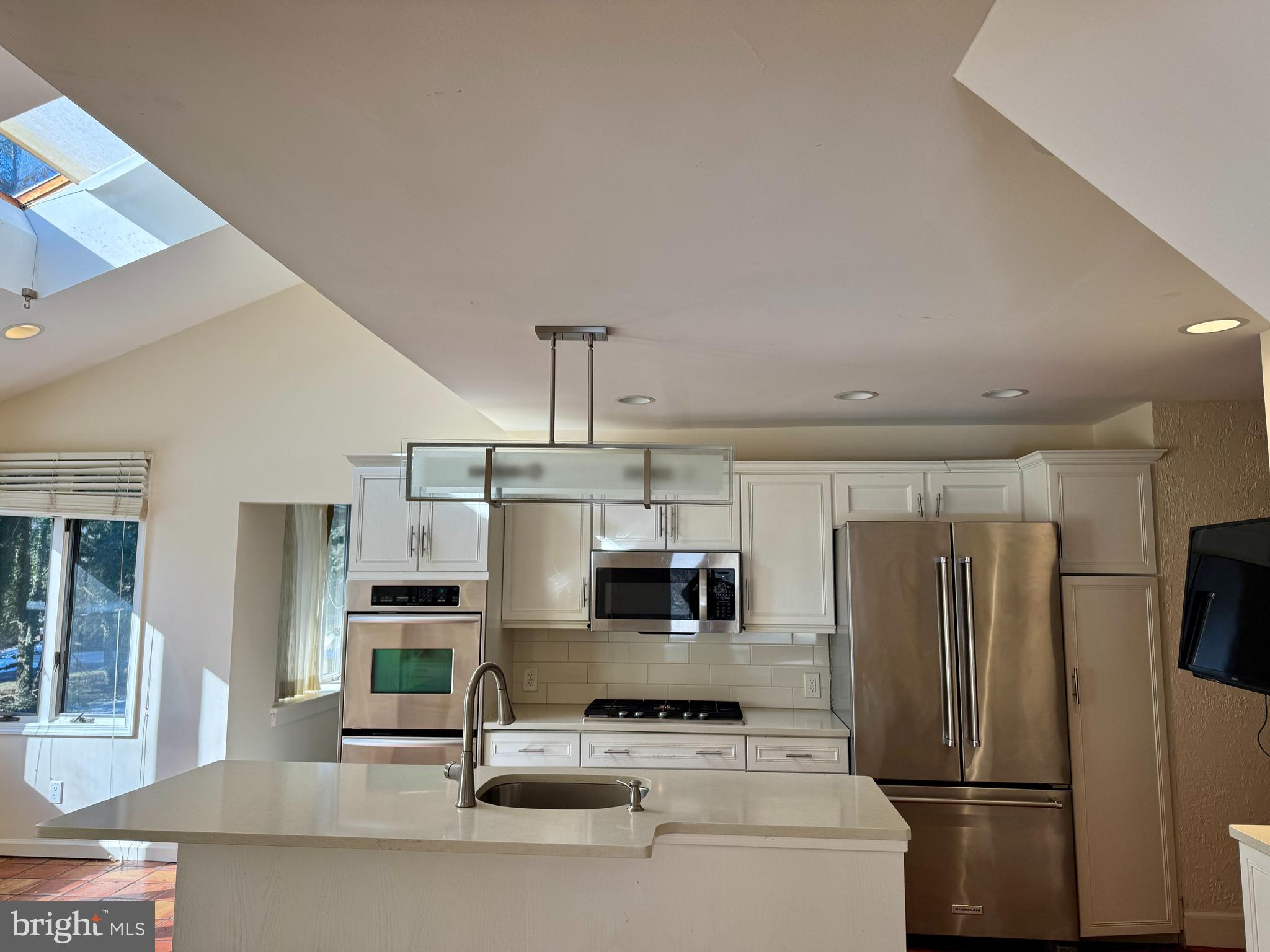 a kitchen with stainless steel appliances a refrigerator a stove a sink dishwasher a oven with white cabinets and stainless steel appliances