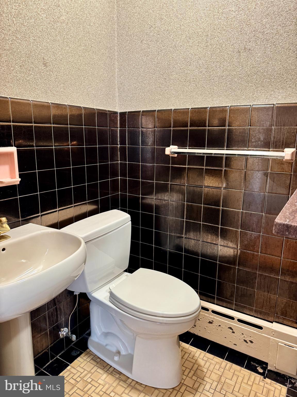 8233 Fairview Road Elkins Park, PA 19027 - Photo 11 of 36 a bathroom with a toilet a sink a mirror and a shower