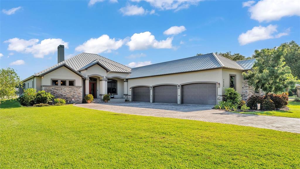 a front view of house with yard and trees in the background