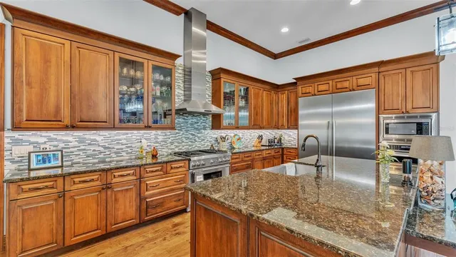 a view of a kitchen with stainless steel appliances granite countertop a refrigerator and a stove