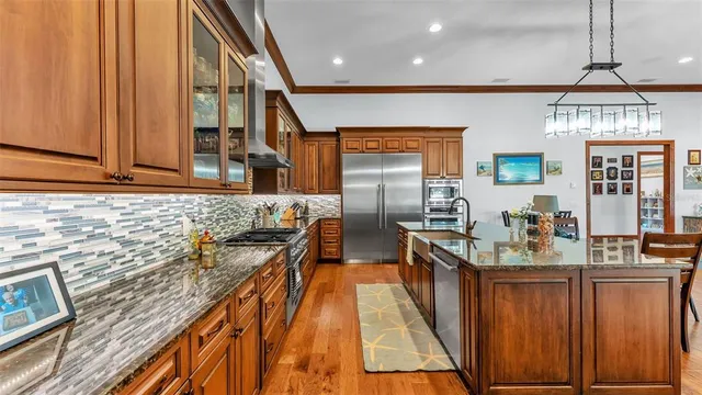 a kitchen with stainless steel appliances granite countertop a refrigerator stove and sink