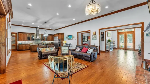 a view of a hallway with wooden floor and a chandelier