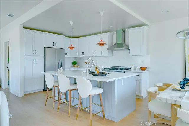 a kitchen with a sink white cabinets and wooden floor
