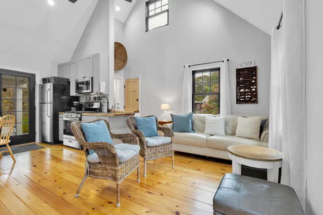 a living room with fireplace furniture and a large window