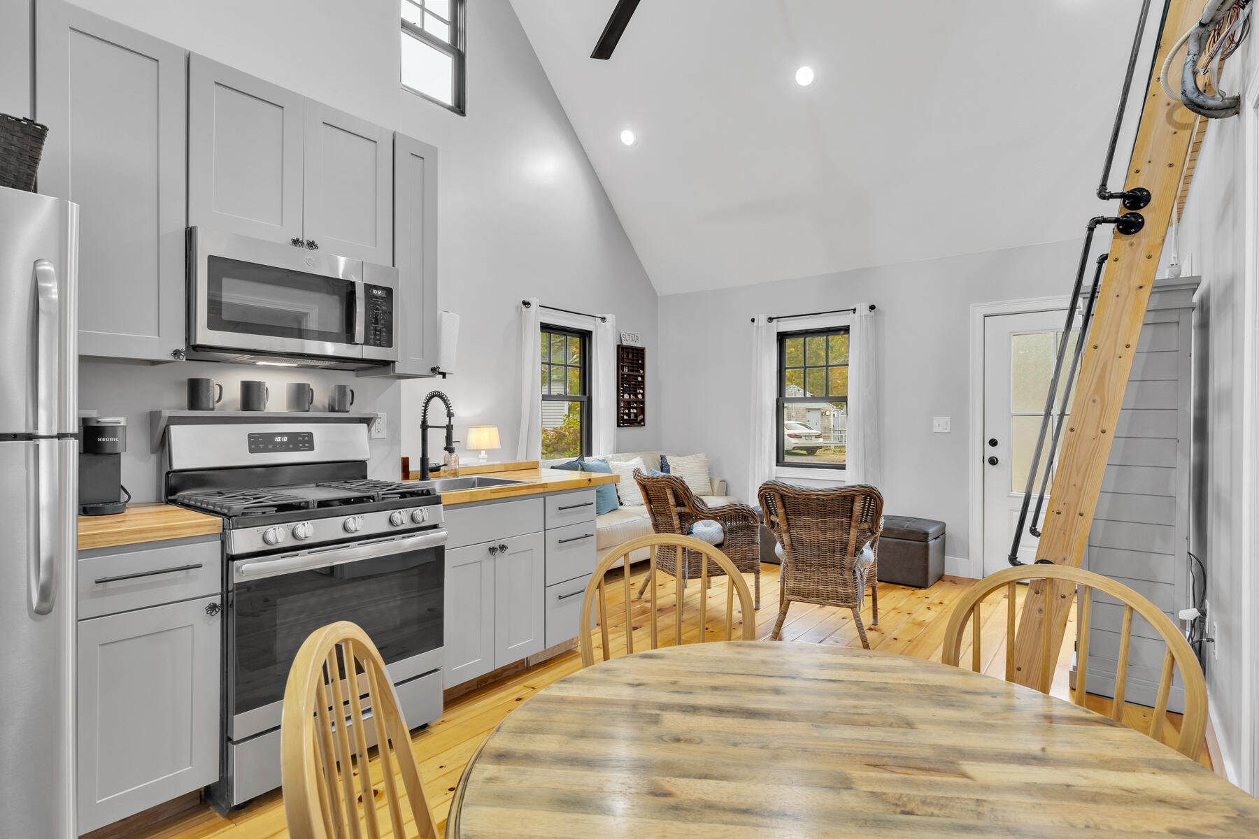 262 Old Wharf Road, Unit 87 Dennis Port, MA 02639 - Photo 16 of 39 a kitchen with stainless steel appliances granite countertop a stove top oven a sink a dining table and chairs with wooden floor