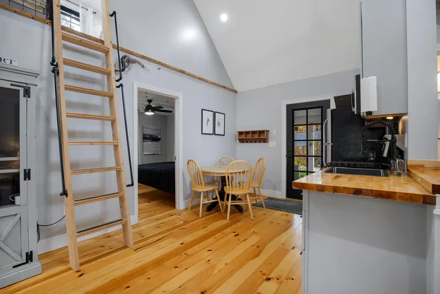 a dining room with wooden floor and furniture