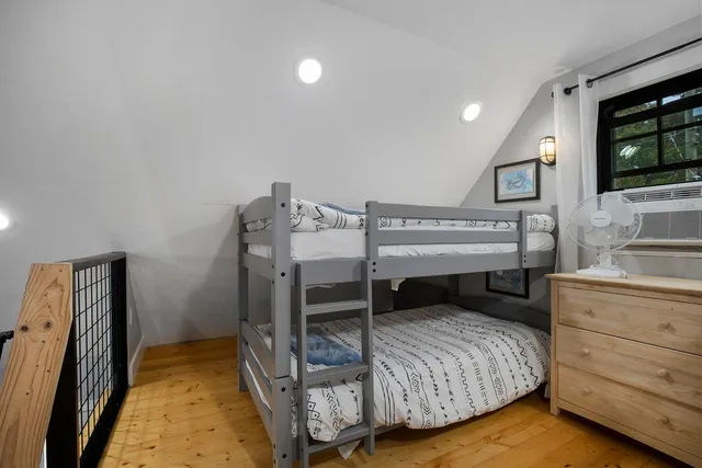 a bedroom with a bed and a flat tv screen on dresser
