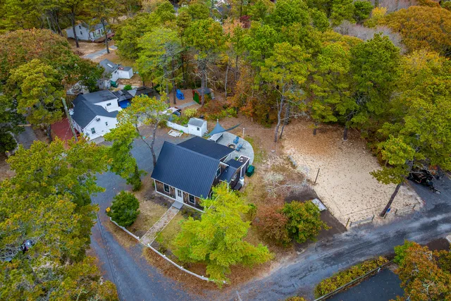 an aerial view of a house with a yard and large trees