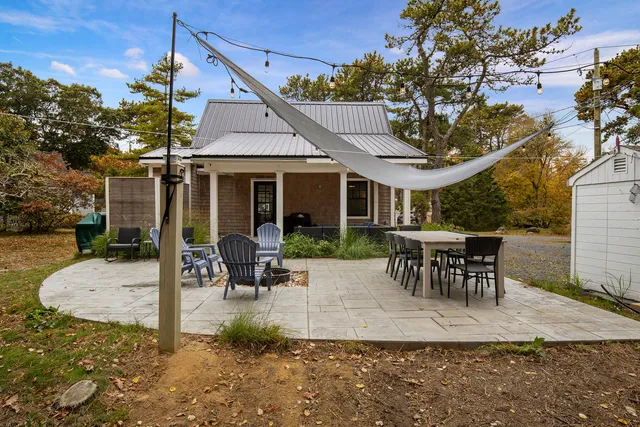 a view of a house with backyard and sitting area