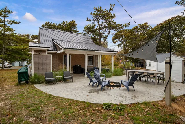a view of a house with backyard and sitting area