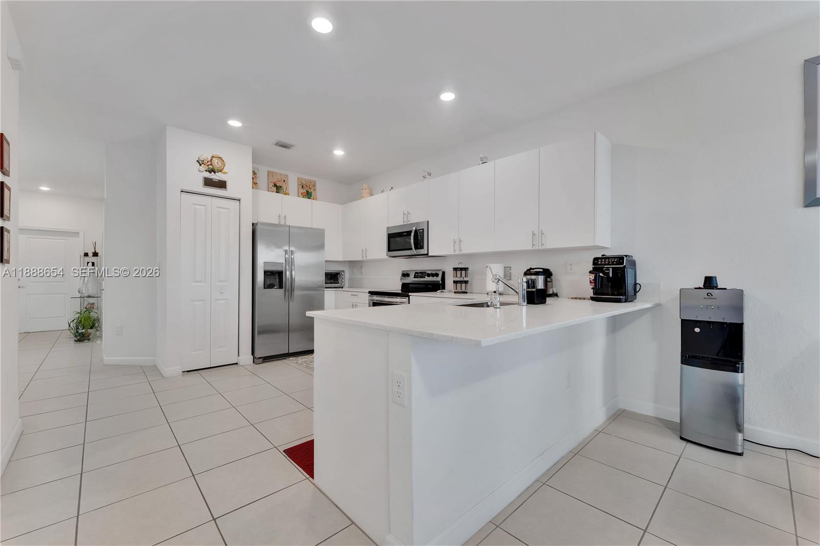 23512 Southwest 129th Path Homestead, FL 33032 - Photo 9 of 39 a kitchen with stainless steel appliances a refrigerator sink and microwave