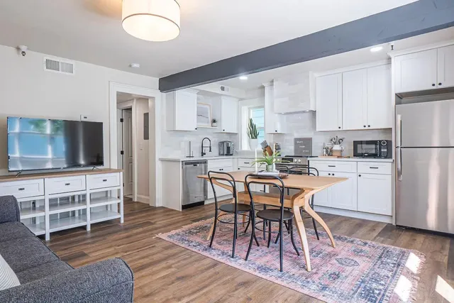 a kitchen with cabinets stainless steel appliances a sink and wooden floor