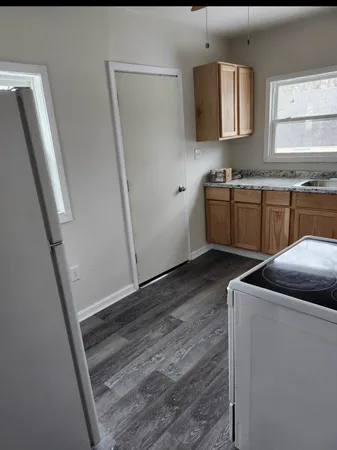 a kitchen with stainless steel appliances granite countertop a sink a stove a microwave a refrigerator a vanity and a window