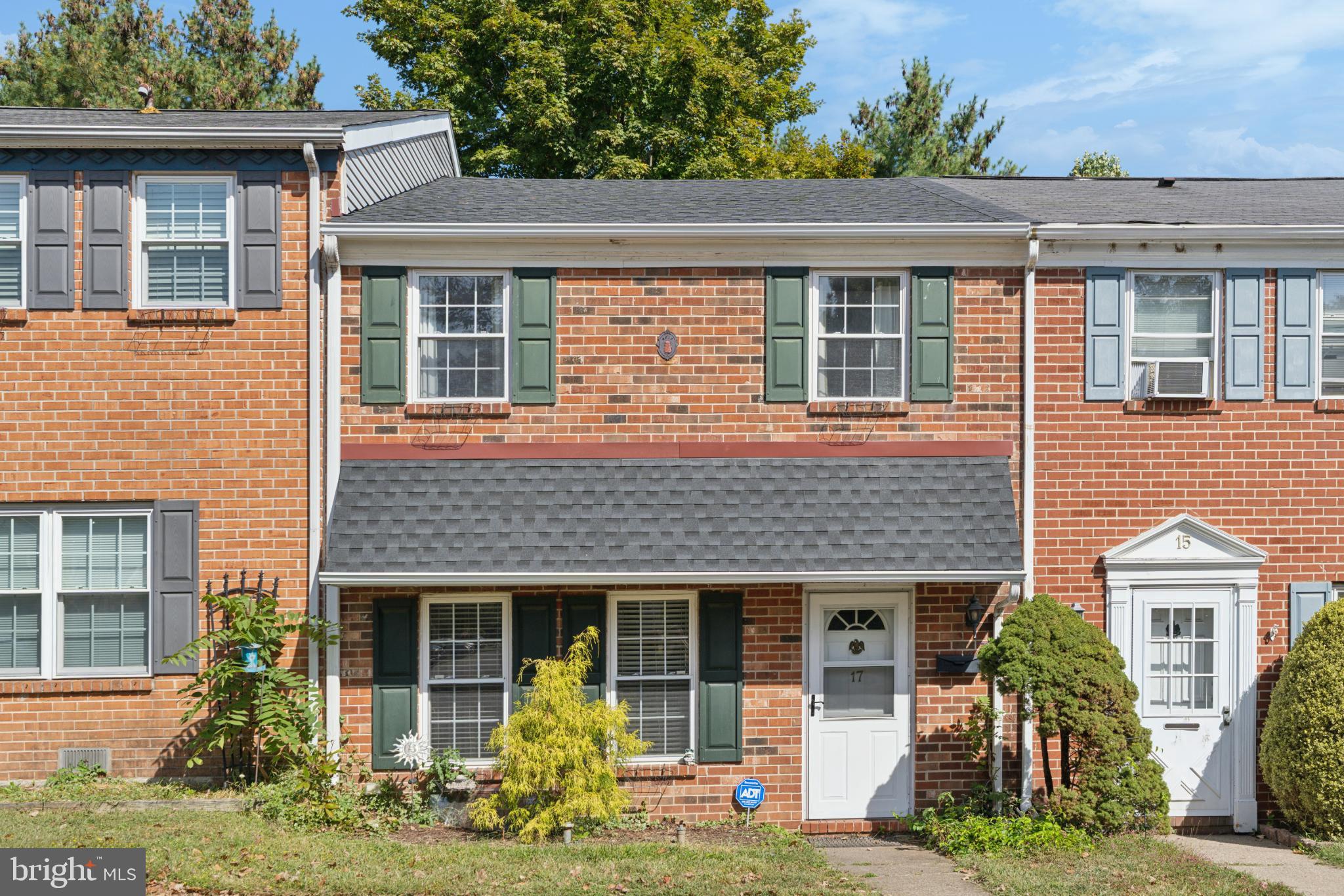 Charming brick townhouse with lush greenery.