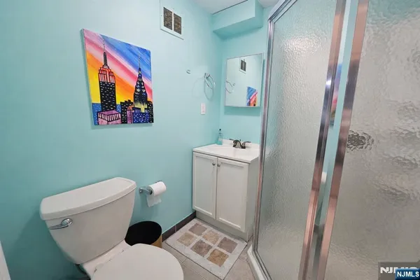 a white toilet sitting next to a bathroom sink and vanity