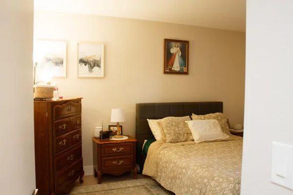a bed room with a bed and painting on the wall