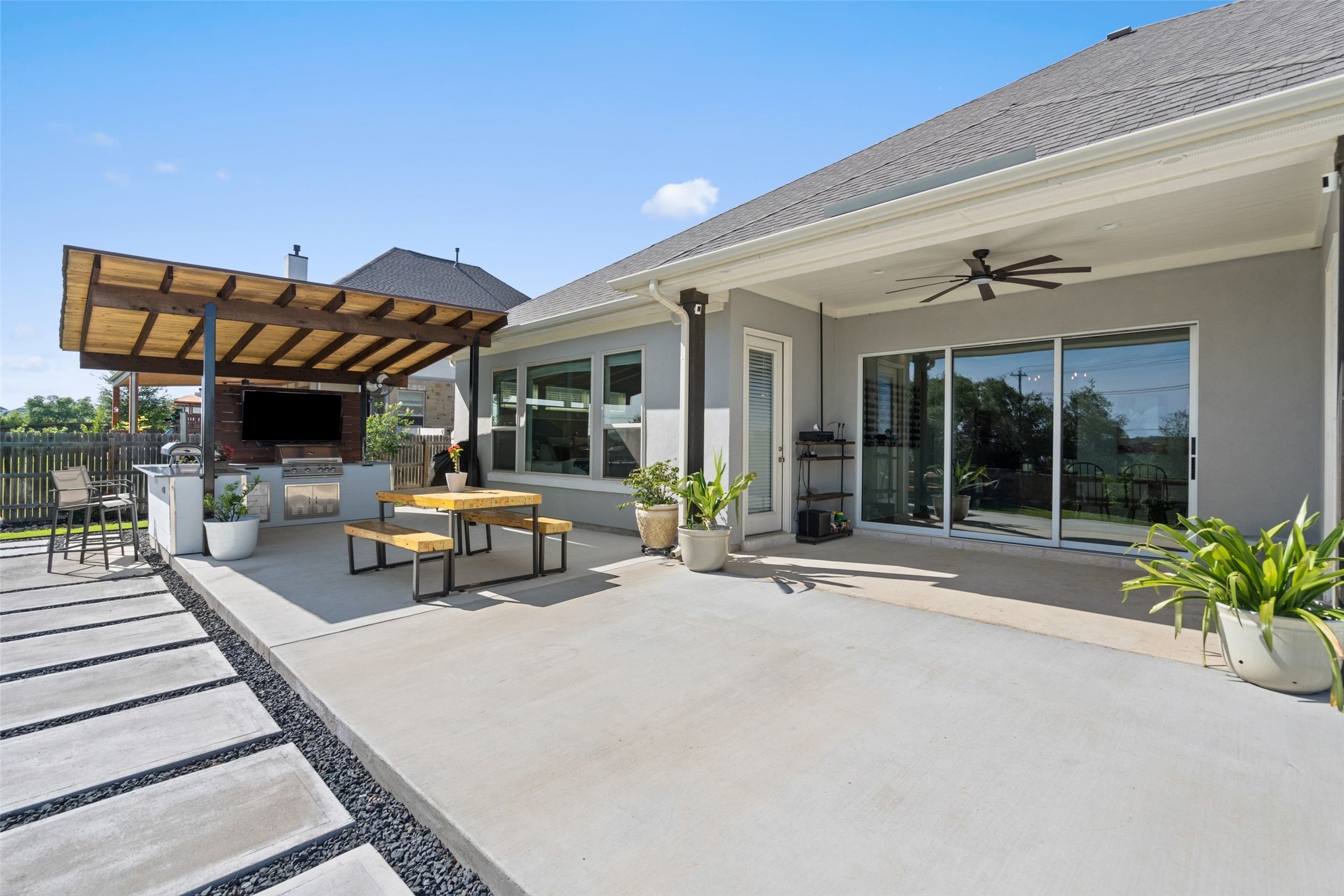 162 Lunar Loop Austin, TX 78737 - Photo 26 of 40 a view of a patio with table and chairs potted plants with wooden floor and fence