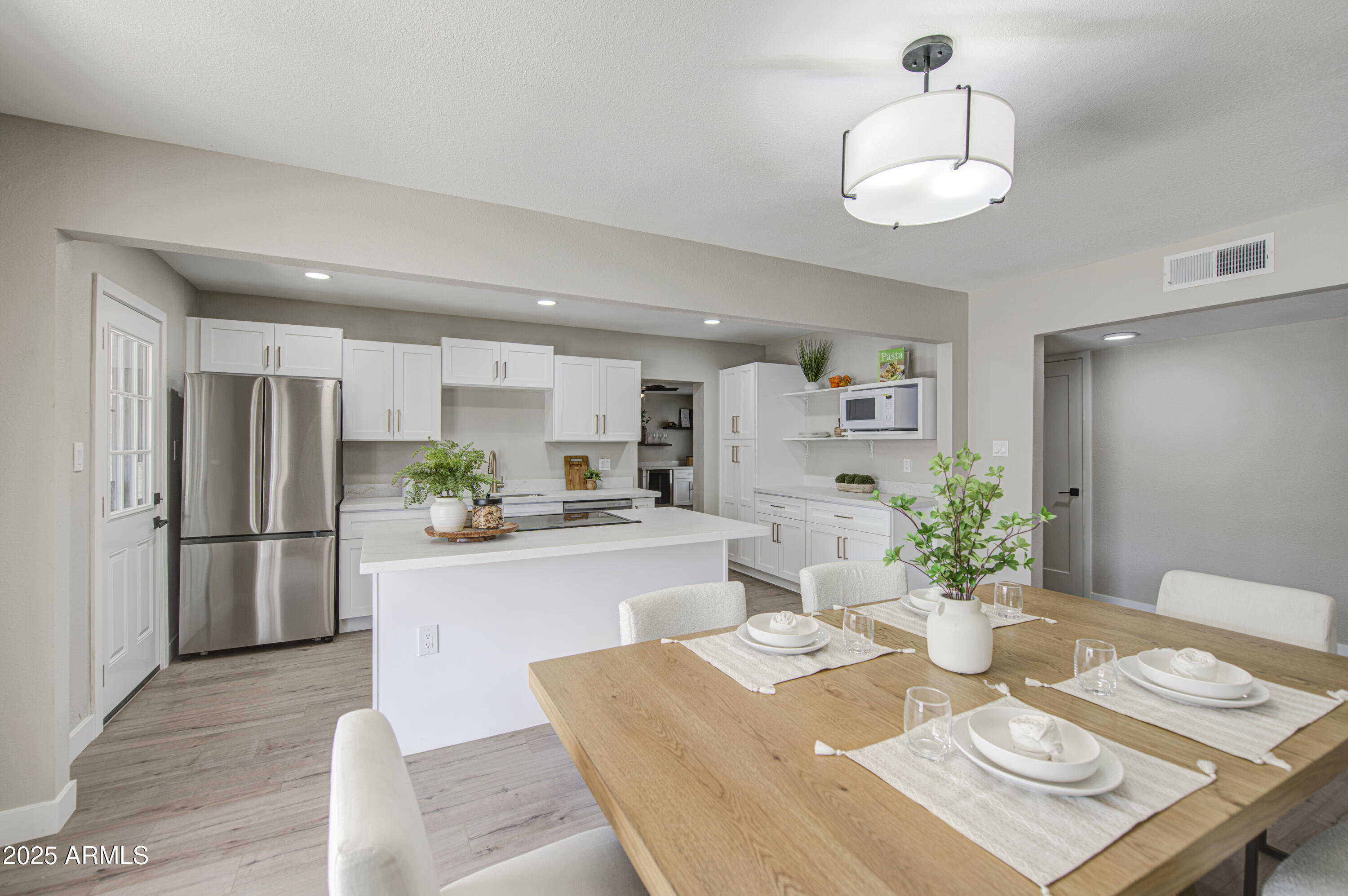 4750 North 39th Drive Phoenix, AZ 85019 - Photo 13 of 39 a kitchen with stainless steel appliances granite countertop a refrigerator a stove a sink dishwasher and white cabinets with wooden floor