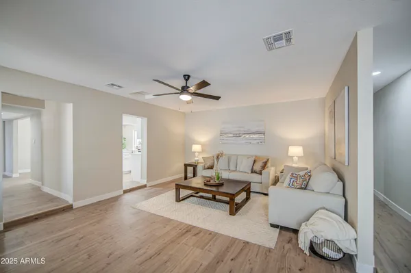 a view of a room with wooden floor and a ceiling fan