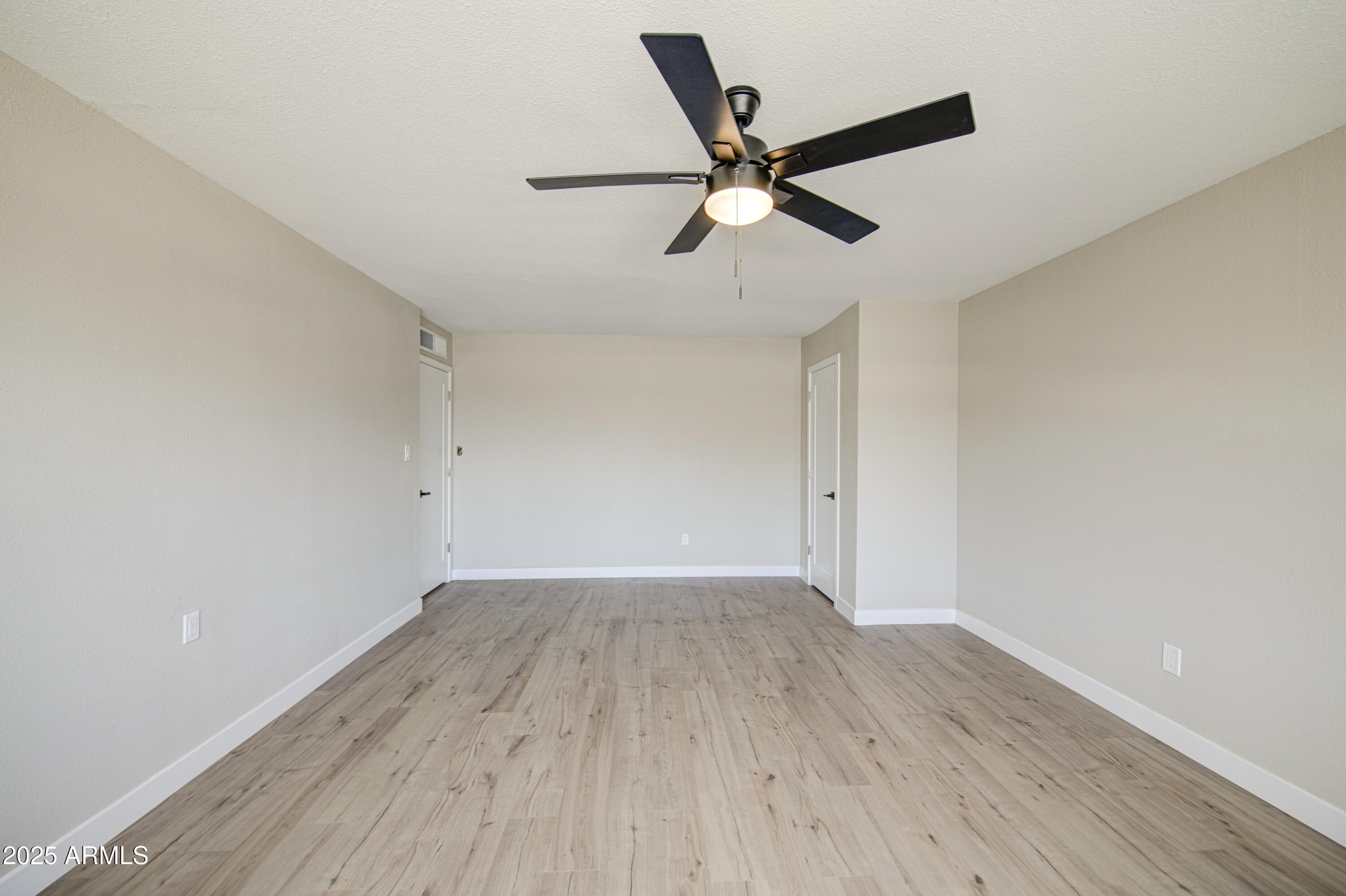 4750 North 39th Drive Phoenix, AZ 85019 - Photo 27 of 39 an empty room with wooden floor and windows