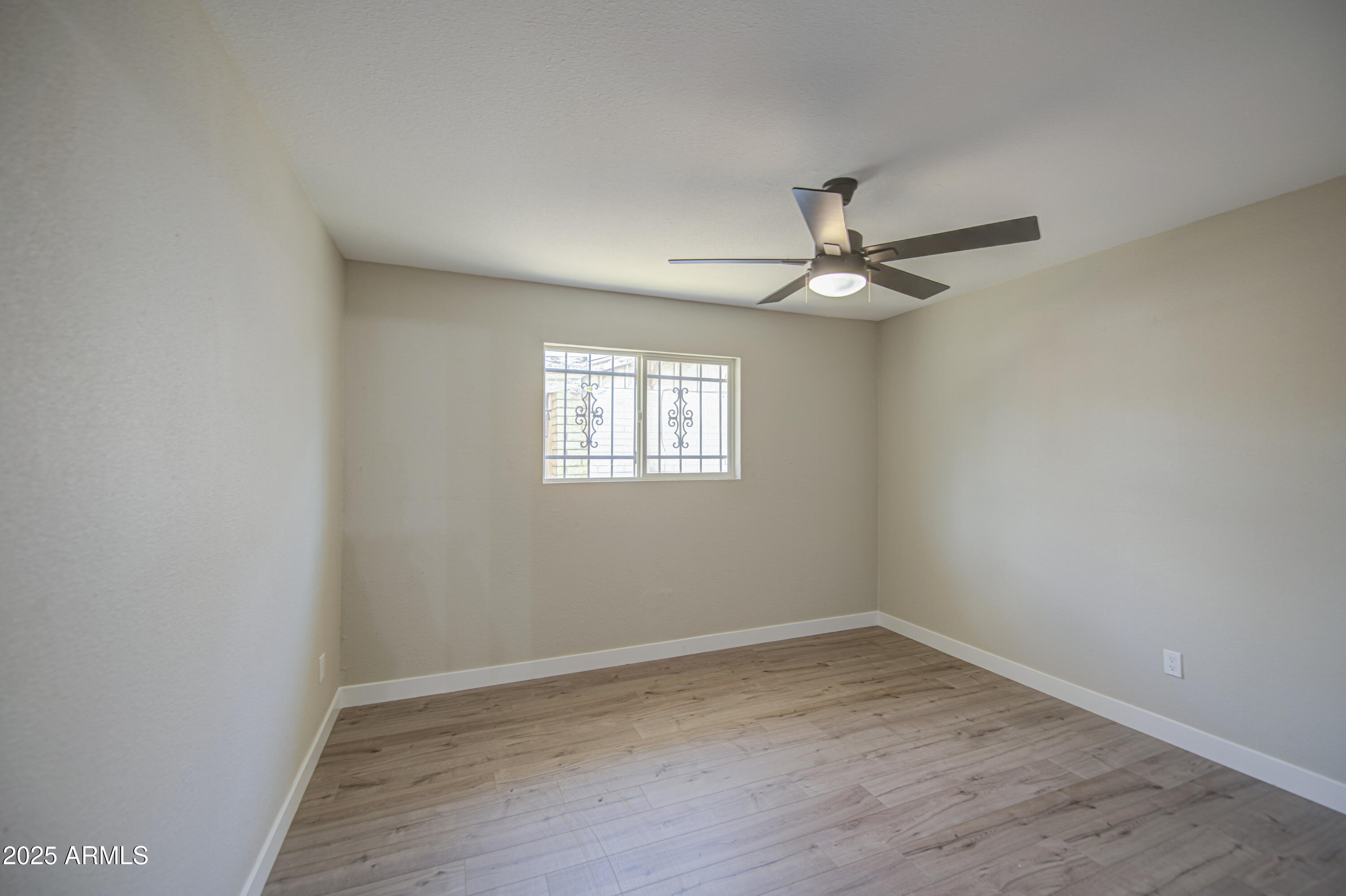 4750 North 39th Drive Phoenix, AZ 85019 - Photo 28 of 39 wooden floor in an empty room with a window
