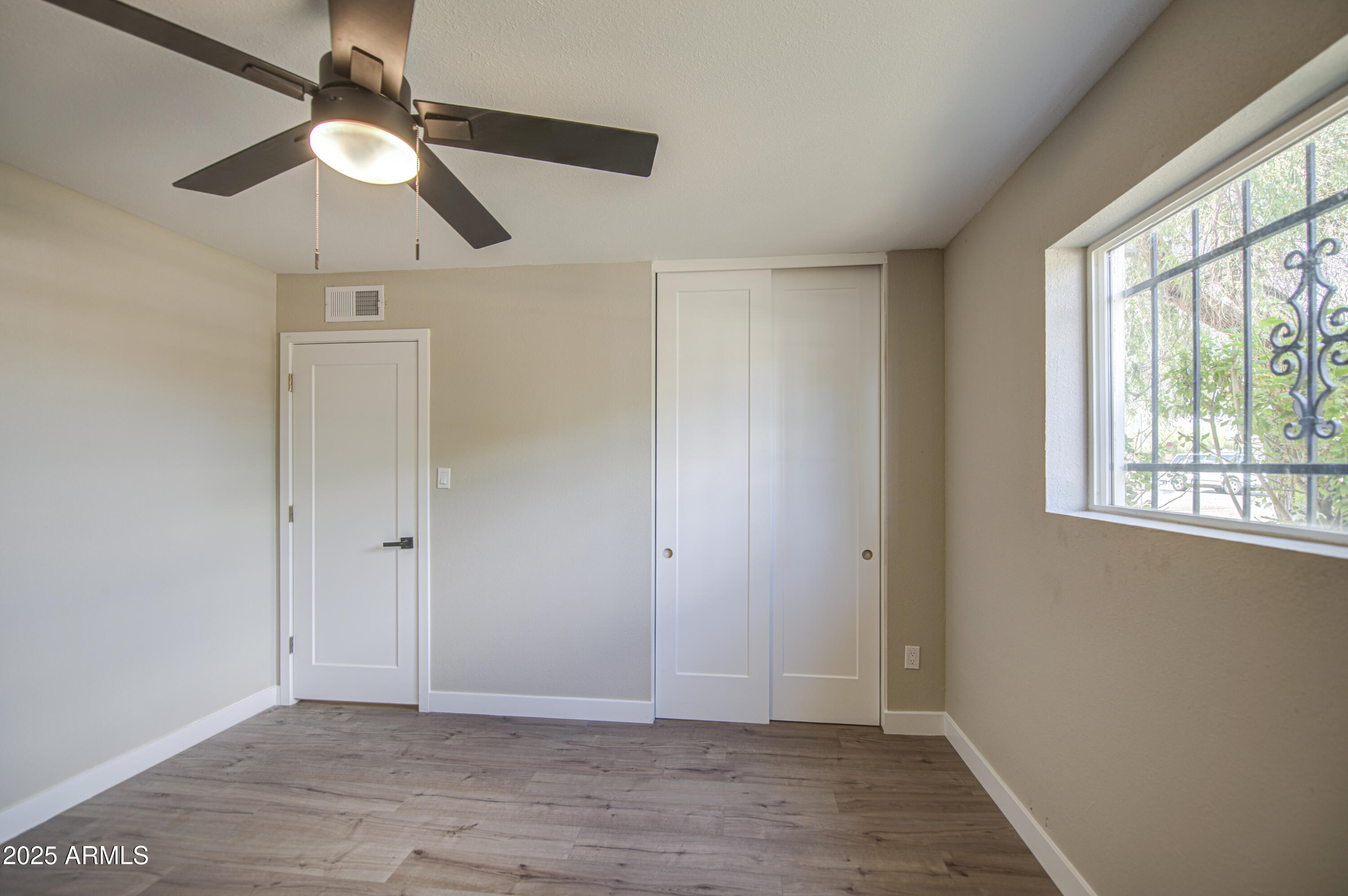 4750 North 39th Drive Phoenix, AZ 85019 - Photo 33 of 39 a view of an empty room with wooden floor and a window