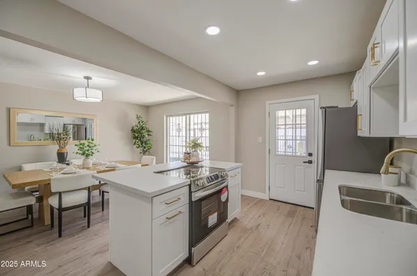 a kitchen that has a sink a table and chairs in it