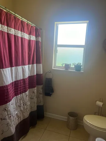 a bathroom with a toilet and a window