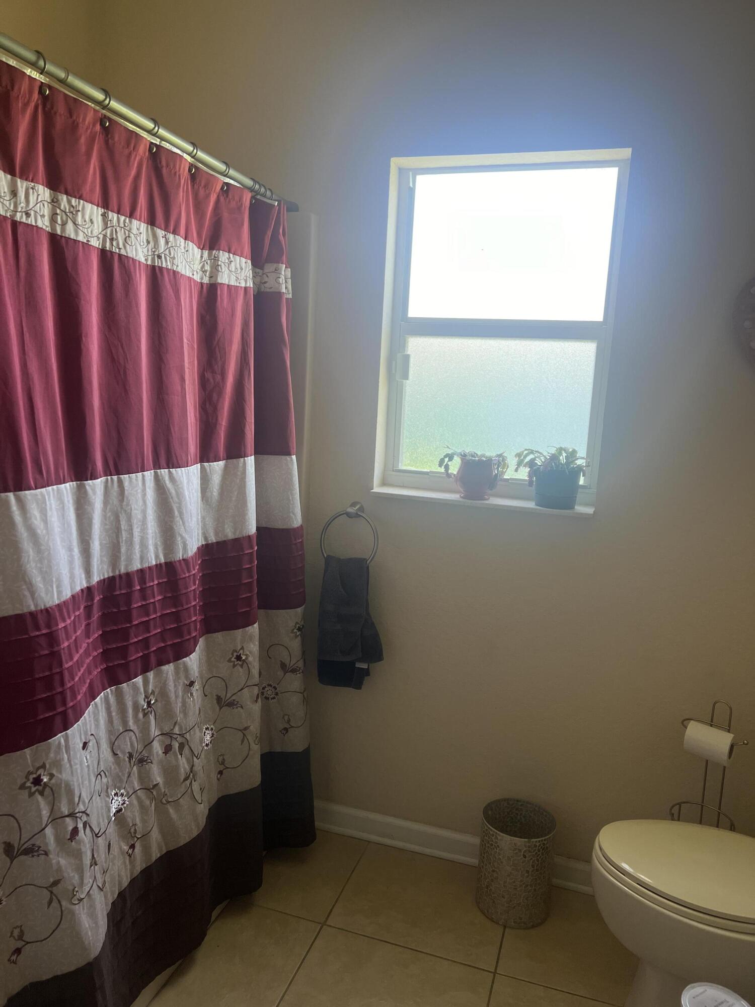 944 Southeast Browning Avenue Port St. Lucie, FL 34983 - Photo 11 of 18 a bathroom with a toilet and a window