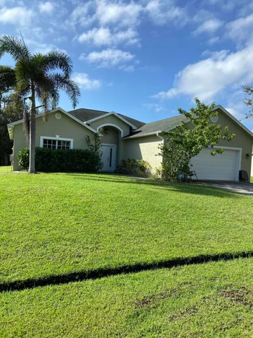 a front view of a house with a garden