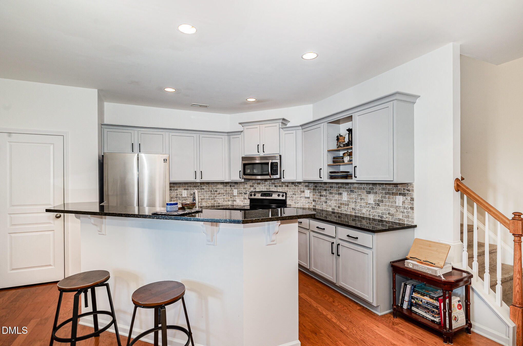 513 Dragby Lane Raleigh, NC 27603 - Photo 10 of 30 a kitchen with stainless steel appliances granite countertop a stove top oven a sink dishwasher a refrigerator and white cabinets with wooden floor
