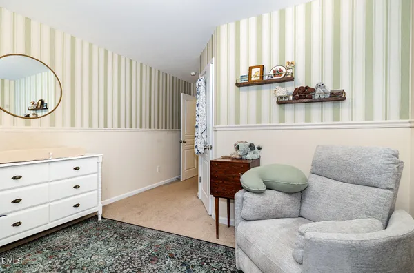 a view of a bedroom with baby crib and furniture