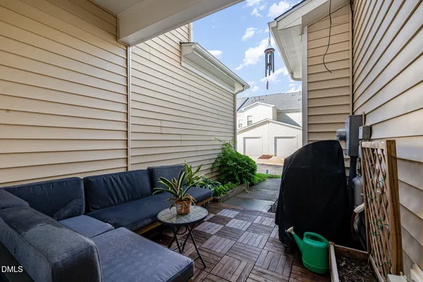 a backyard of a house with barbeque oven and potted plants