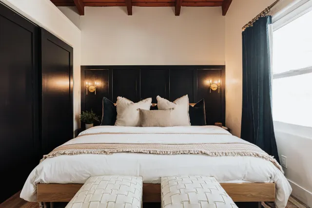 a living room with furniture a flat screen tv and floor to ceiling window