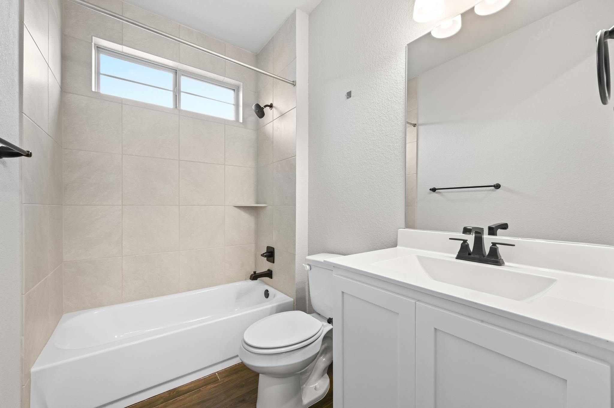 8003 Orizzonte Street Austin, TX 78744 - Photo 16 of 25 Full bathroom with shower / tub combination, vanity, dark wood finished floors, and a textured wall